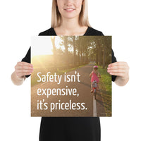 A safety poster showing a little girl riding her bike down a road on a sunny day with the slogan safety isn't expensive, it's priceless.