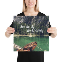 A workplace safety poster depicting a beautiful landscape of mountains in the background of a lake with a little wooden boat in the lake with text saying live safely work safely.