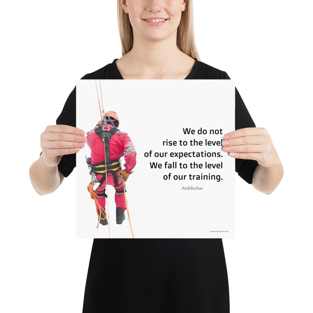 A safety poster showing a worker performing a controlled descent while wearing a fall protection harness on a bright white background with a quote from Archilochus to the right.