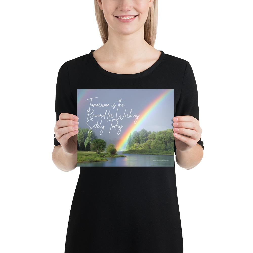 A workplace safety poster showing bright forest scene with a lake and vibrant green trees and a colorful rainbow coming out of the forest with the slogan tomorrow is the reward for working safely today.