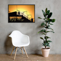 A workplace safety poster showing a construction site and construction workers being silhouetted by a bright and beautiful sunset of different shades of orange with the slogan safety first, safety always.