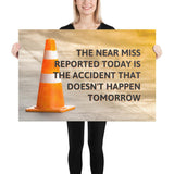 A workplace safety poster showing an orange safety cone with the slogan the near miss reported today is the accident that doesn't happen tomorrow.