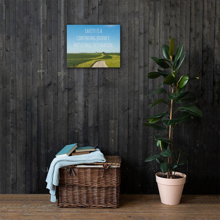 A workplace safety poster depicting a beautiful sunny day with a bright blue sky and a lush green field being cut down the middle by a dirt road leading off into the countryside with the text safety is a continuing journey, not a final destination.