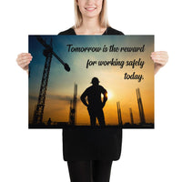 A safety poster showing a worker on a construction site being silhouetted by a sunset of orange and blue colors with the slogan tomorrow is the reward for working safely today.