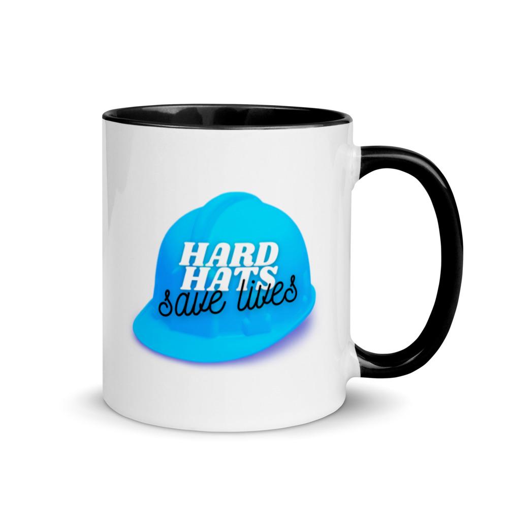 White ceramic mug with a blue hard hat with text that says "Hard hats save lives" with a black rim, inside, and handle.