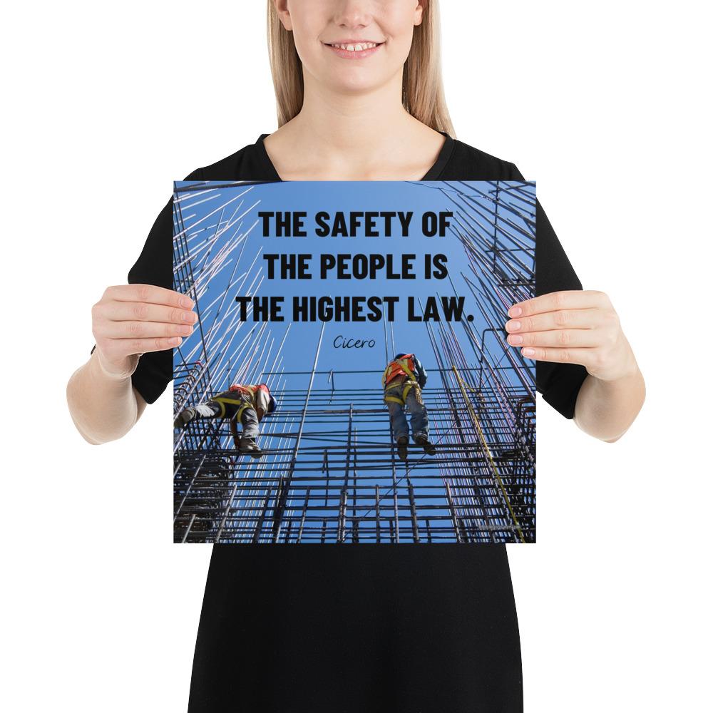A safety poster showing construction workers scaling rebar with a bright blue sky as the background and a safety quote in black block text.