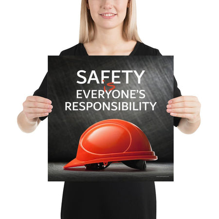 A workplace safety poster showing a red hard hat in front of a grey, industrial-looking background with the slogan safety is everyone's responsibility.
