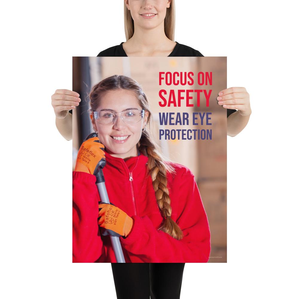 An eye safety poster of a young woman wearing safety glasses and orange gloves smiling as she works in a warehouse with a safety slogan in the top right corner.