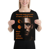 An eye safety poster of a close up of a mans face with his eyes wide open with text and PPE infographics covering his left eye.