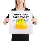 A workplace safety poster showing a yellow hard hat on a plain white background with the slogan were you safe today, or just lucky?