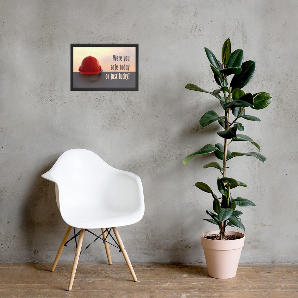 A workplace safety poster showing a red hard hat sitting on a grey wall with a dreamy sunset background and the slogan were you safe today, or just lucky?