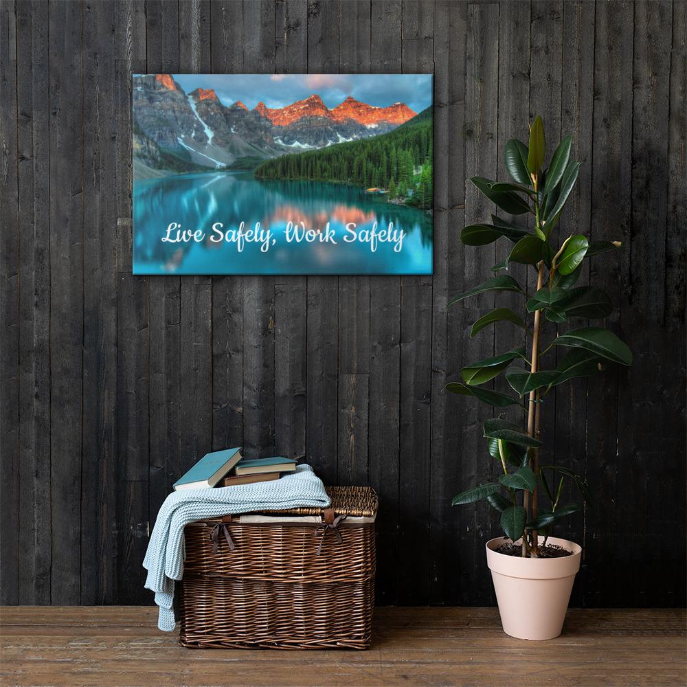 A workplace safety poster depicting a beautiful landscape of mountains with a river flowing down the side of the mountains into a bright blue pond with text saying live safely work safely.