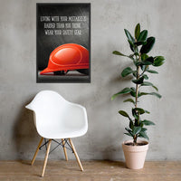 A workplace safety poster showing a bright red hard hat with an ominous black background with the slogan living with your mistakes is harder than you think, wear your safety gear.