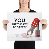 A workplace safety poster showing a lockout tagout lock and tag with the text you are the key to safety.