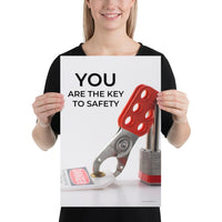A workplace safety poster showing a lockout tagout lock and tag with the text you are the key to safety.