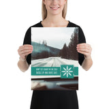 A safety poster showing a picture taken from the dashboard of a car showing an iced over road in the mountains with the slogan don't get caught in the cold, buckle up and stay safe.