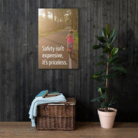 A safety poster showing a little girl riding her bike down a road on a sunny day with the slogan safety isn't expensive, it's priceless.
