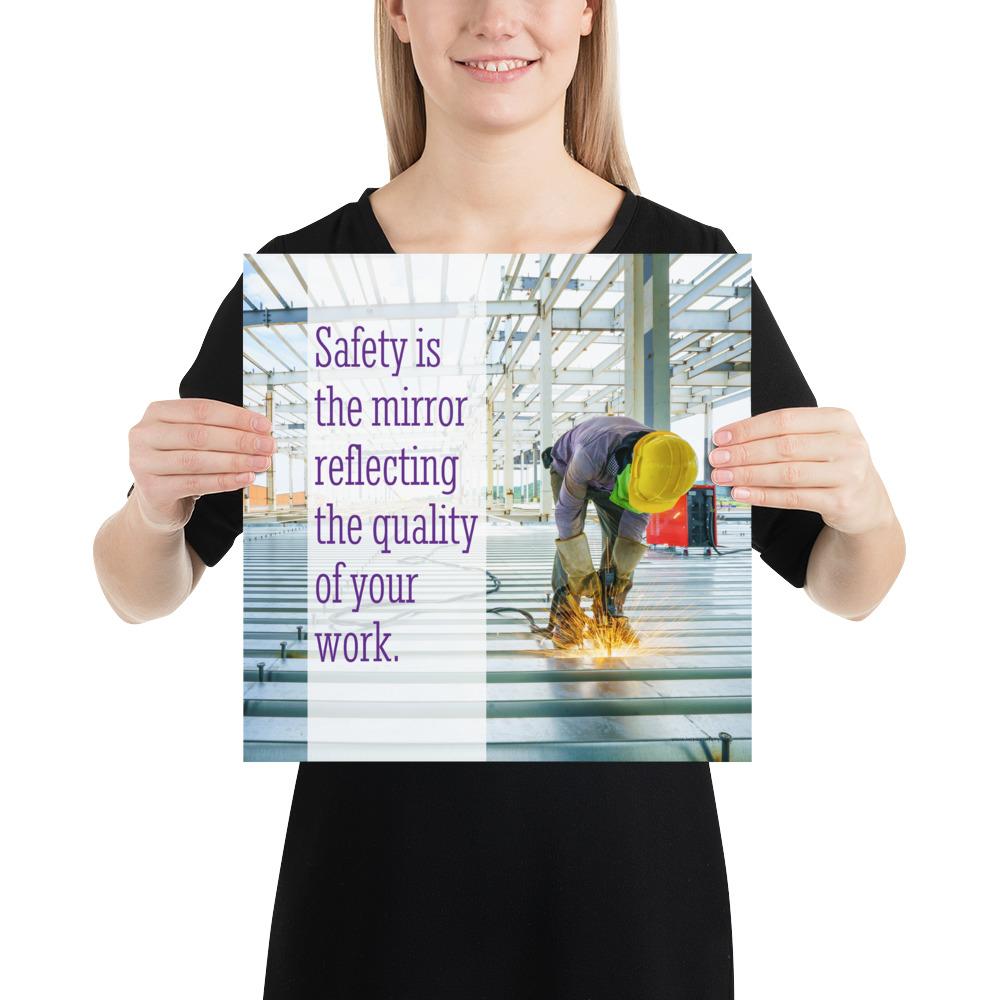 A workplace safety poster showing a construction worker wearing all of the proper PPE and bending over to work on a huge sheet of metal with sparks flying everywhere with the slogan safety is the mirror reflecting the quality of your work.