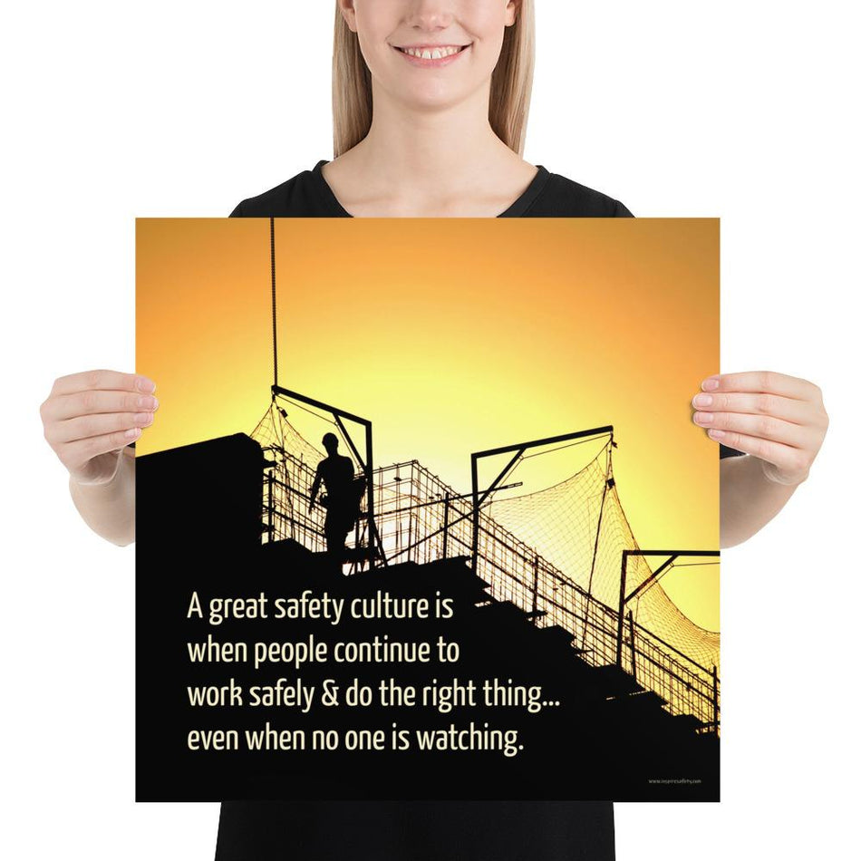 A construction safety poster showing the silhouette of a construction worker working on a building with a bright yellow sunset in the background and a safety slogan in the bottom left corner.