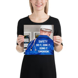 Safety poster showing an electrician wearing a hard hat and holding cables working on an electrical panel with text on the back of his bright blue shirt.