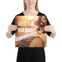 A safety poster showing a close-up of a man's hands holding a chainsaw sawing through a log with sawdust flying everywhere with the text safety is in your hands to the left.