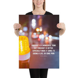 A workplace safety poster depicting a bright orange construction traffic light in the foreground of a blurry nighttime cityscape with a safety quote by William Blake.