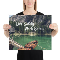 A workplace safety poster depicting a beautiful landscape of mountains in the background of a lake with a little wooden boat in the lake with text saying live safely work safely.