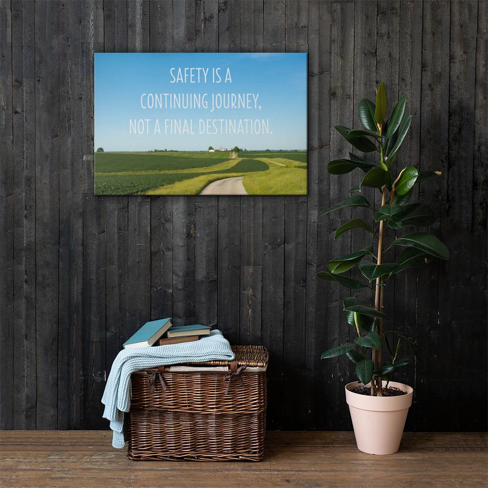 A workplace safety poster depicting a beautiful sunny day with a bright blue sky and a lush green field being cut down the middle by a dirt road leading off into the countryside with the text safety is a continuing journey, not a final destination.