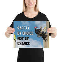 A fully harnessed man wearing a hard hat scaling the side of a building with a bright blue sky and clouds in the background with the text safety by choice, not by chance in bold text to his left.