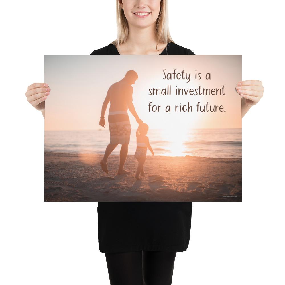 A workplace safety poster showing a father and his young daughter walking on the shore of a beach with a beautiful sunset in the background and text saying safety is a small investment for a rich future.