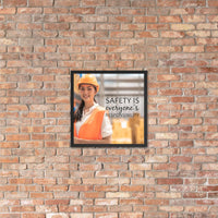A workplace safety poster showing a young warehouse worker in a yellow hardhat and orange reflective vest holding a clipboard and smiling with the slogan safety is everyone's responsibility.