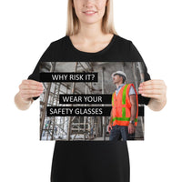 A safety poster showing a construction worker in a reflective orange vest, hard hat, and safety glasses on a construction site looking out with a safety slogan to the left.