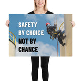 A fully harnessed man wearing a hard hat scaling the side of a building with a bright blue sky and clouds in the background with the text safety by choice, not by chance in bold text to his left.