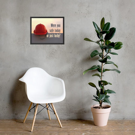 A workplace safety poster showing a red hard hat sitting on a grey wall with a dreamy sunset background and the slogan were you safe today, or just lucky?