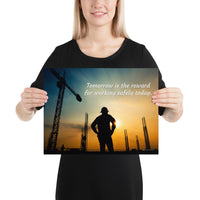 A safety poster showing a worker on a construction site being silhouetted by a sunset of orange and blue colors with the slogan tomorrow is the reward for working safely today.