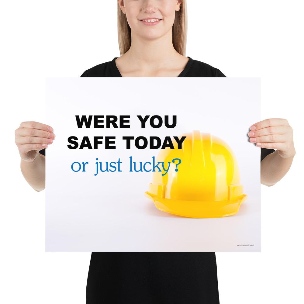 A workplace safety poster showing a yellow hard hat on a plain white background with the slogan were you safe today, or just lucky?