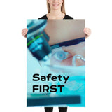 A safety poster showing a close up of a lab worker's eyes examining a sample on a microscope while wearing safety glasses and a mask with the slogan safety first in bold letters.