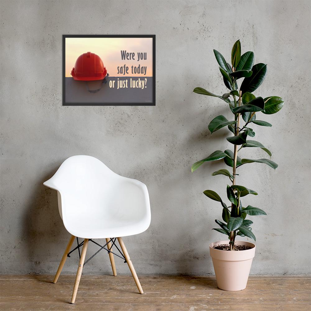 A workplace safety poster showing a red hard hat sitting on a grey wall with a dreamy sunset background and the slogan were you safe today, or just lucky?