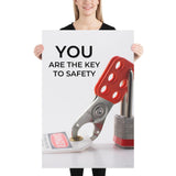 A workplace safety poster showing a lockout tagout lock and tag with the text you are the key to safety.