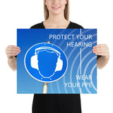 A hearing protection poster showing a bright blue construction sign with an illustration of a face wearing ear muffs with sound waves coming from the right and a safety slogan in the upper right and bottom right corners.
