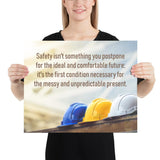A workplace safety poster showing 3 multi colored hardhats sitting on a wall with the slogan safety isn't something you postpone for the ideal and comfortable future. It's the first condition necessary for the messy and unpredictable present.