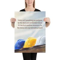 A workplace safety poster showing 3 multi colored hardhats sitting on a wall with the slogan safety isn't something you postpone for the ideal and comfortable future. It's the first condition necessary for the messy and unpredictable present.