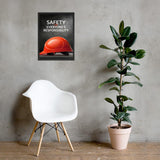 A workplace safety poster showing a red hard hat in front of a grey, industrial-looking background with the slogan safety is everyone's responsibility.