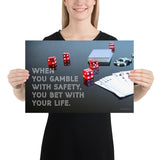 A workplace safety poster of a glossy black table with red dice, playing cards, and poker chips strewn everywhere with a safety slogan in the bottom left corner.