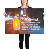A workplace safety poster depicting a bright orange construction traffic light in the foreground of a blurry nighttime cityscape with a safety quote by William Blake.