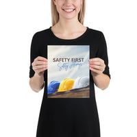 A workplace safety poster showing a white, a yellow, and a blue hardhat sitting on a wall with the slogan safety first, safety always.