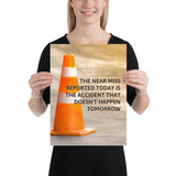 A workplace safety poster showing an orange safety cone with the slogan the near miss reported today is the accident that doesn't happen tomorrow.