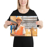 Safety poster showing a female warehouse worker smiling and wearing an orange reflective safety vest and orange hard hat with a safety quote written in dark text.