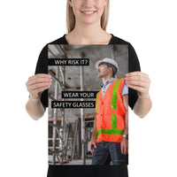 A safety poster showing a construction worker in a reflective orange vest, hard hat, and safety glasses on a construction site looking out with a safety slogan to the left.