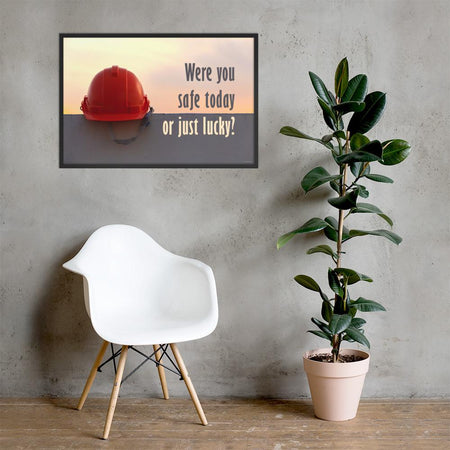 A workplace safety poster showing a red hard hat sitting on a grey wall with a dreamy sunset background and the slogan were you safe today, or just lucky?